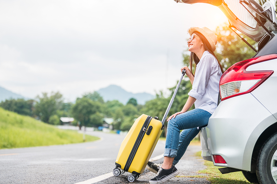 Asian Woman Spending Weekend In Roadtrip With Yellow Luggage. Gi