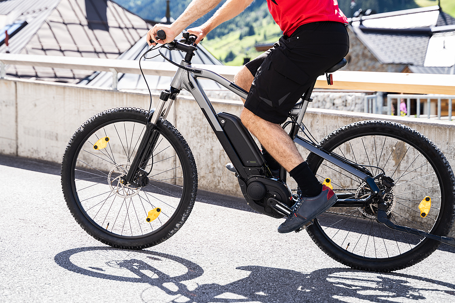 Man Riding E Bike Bicycle In City. Electric Bike In Summer