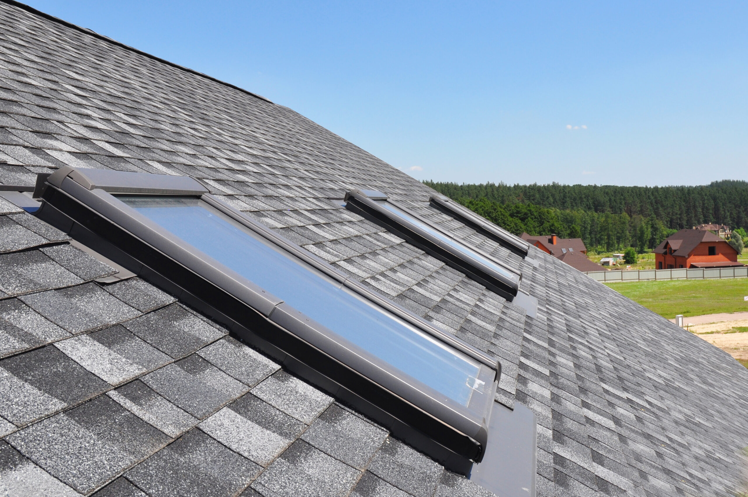Attic skylight. Asphalt Shingles House Roofing Construction with Attic Roof windows skylights waterproofing.