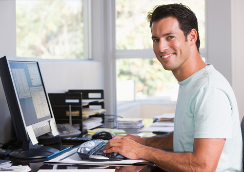 Man Typing on his Computer at His Desk